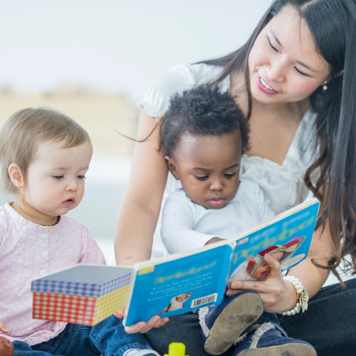 Adult woman reading with two babies