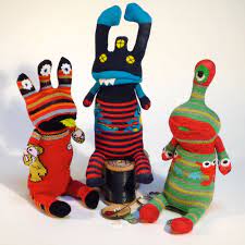 three creatures made out of socks and have googly eyes and colorful vibrant colors