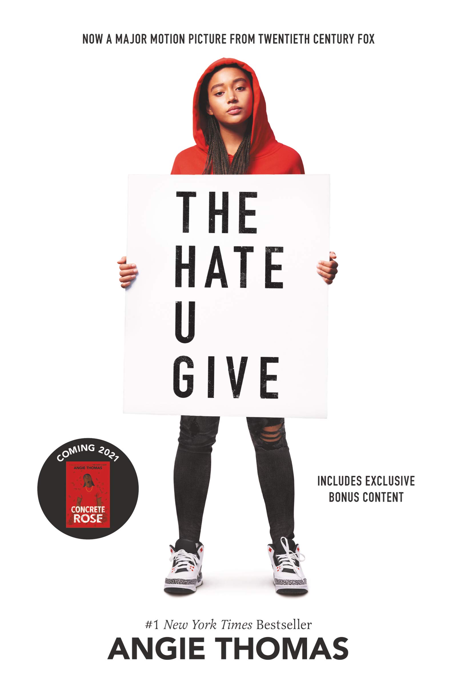 young black girl holding a sign stating the hate u give