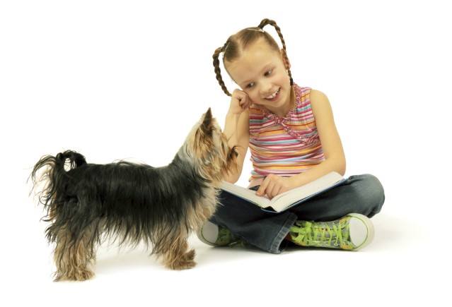 girl reading book to dog