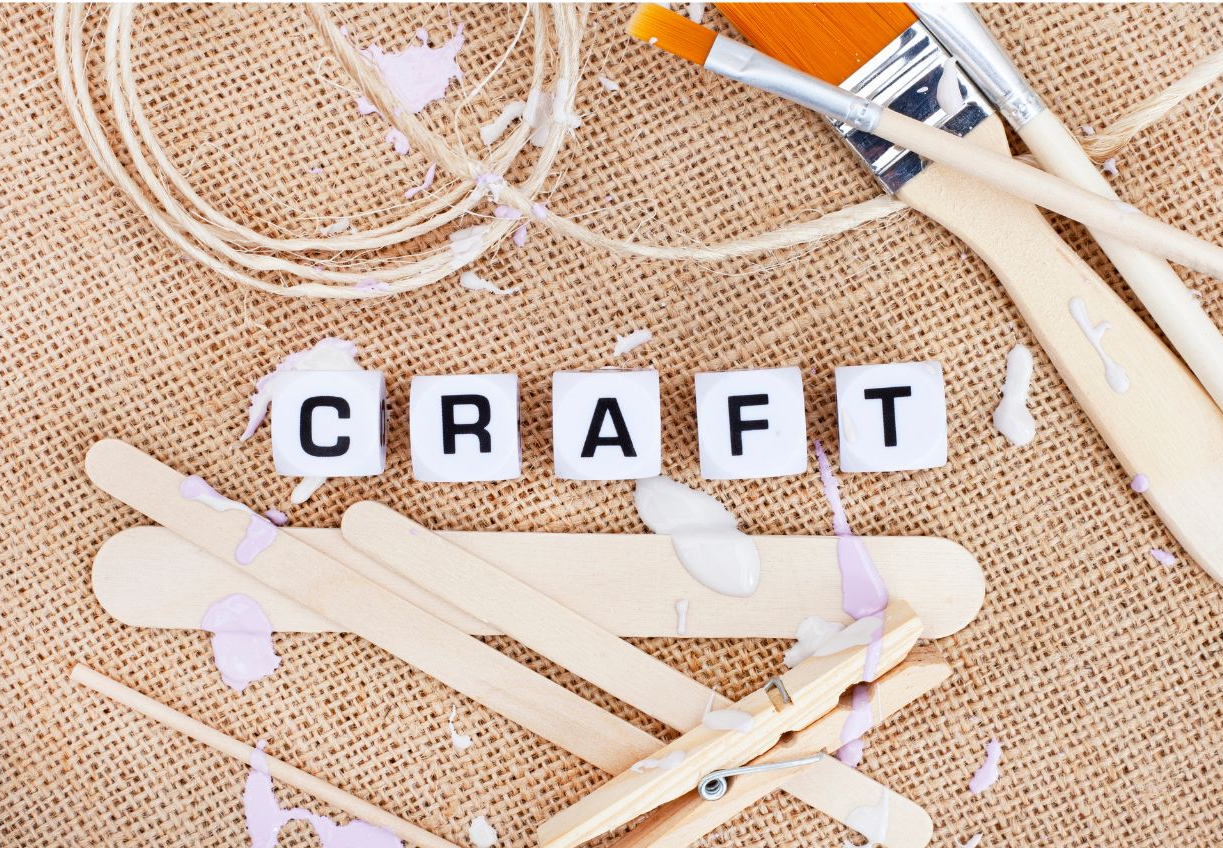 burlap background with crafting supplies and word craft spelled out in beads