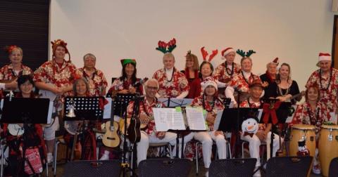 Sunset Strummers group with red aloha shirts and ukuleles