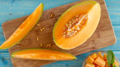 Cantaloupe cut on cutting board with seeds exposed 