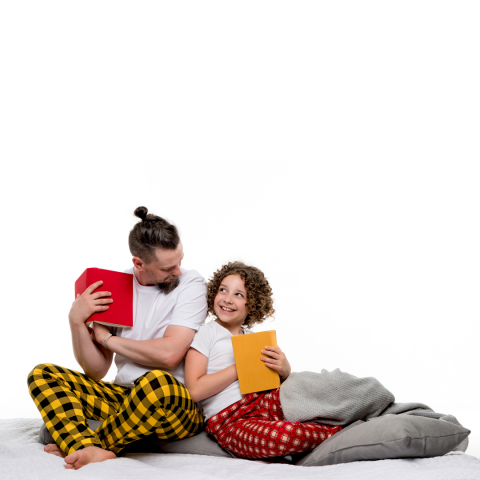 parent or guardian and child in pajamas reading books