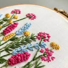 embroidered colorful flowers on fabric in an embroidery hoop
