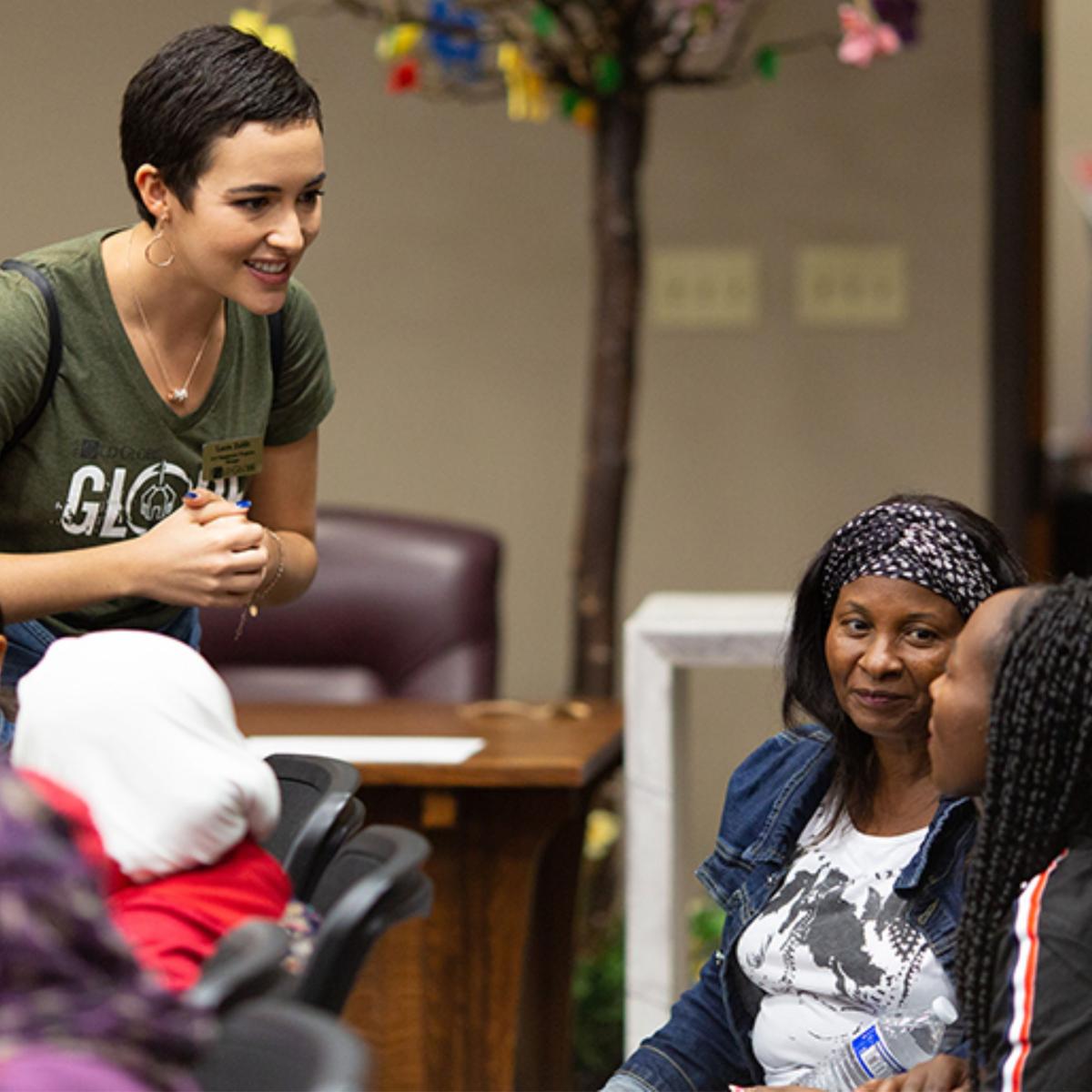 teaching artist standing talking to seated students