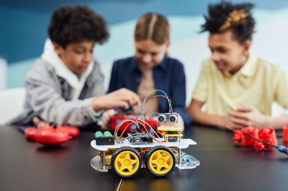 three kids setting up a robot