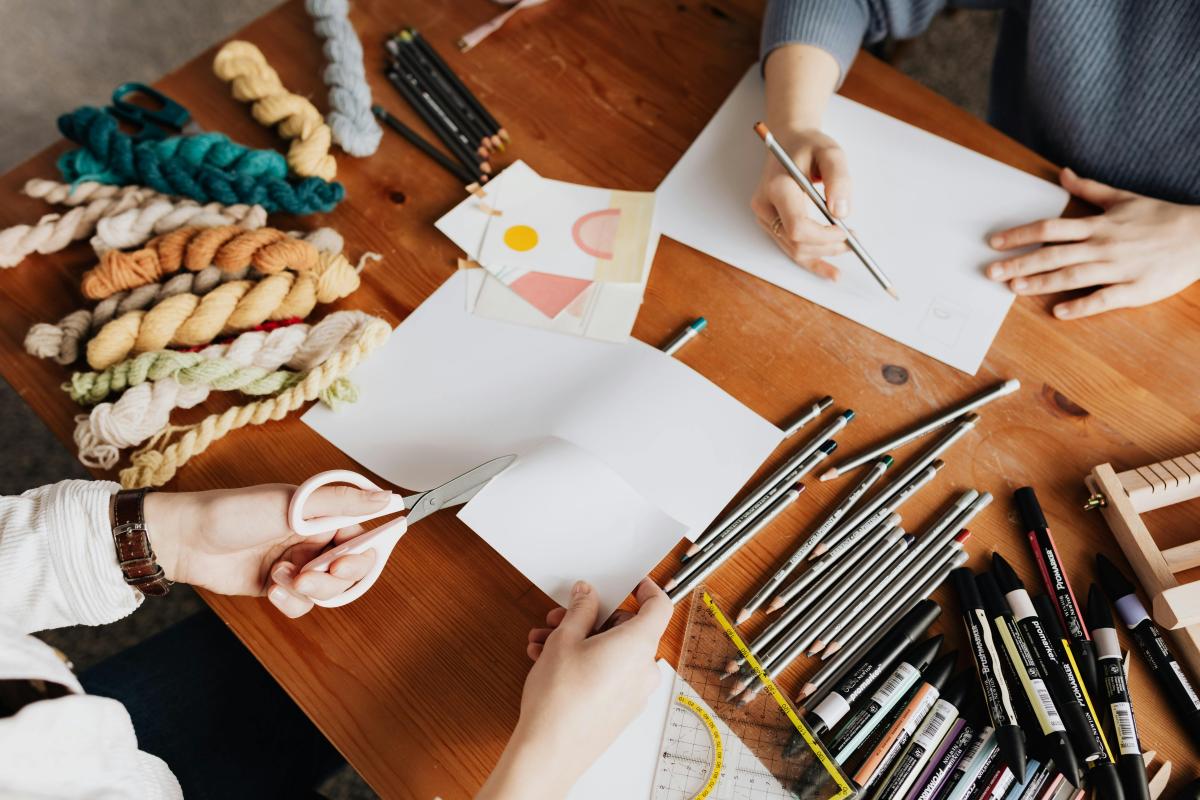 two people making art at a table