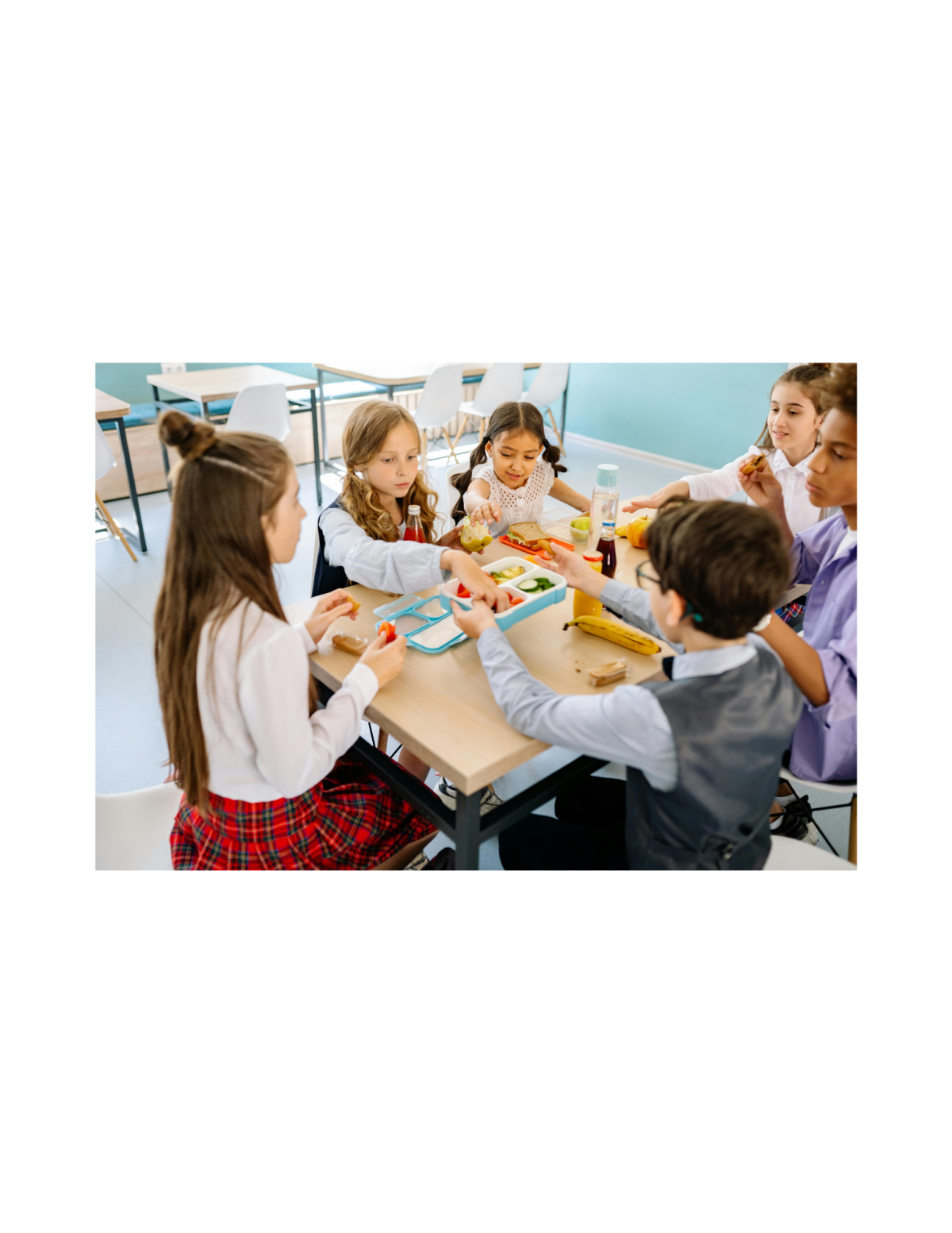 a group of children sitting at a table eating food